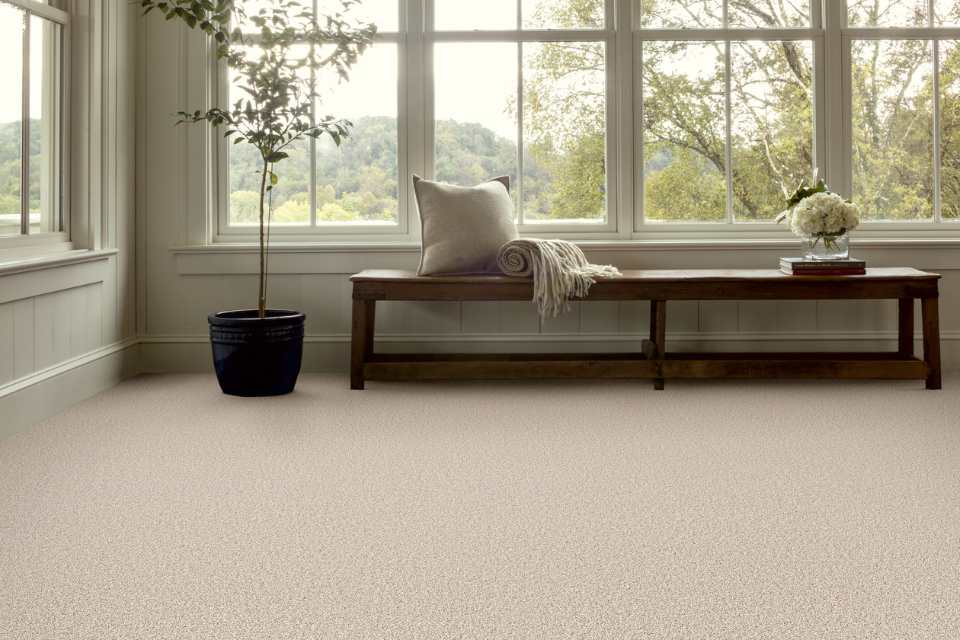 light beige plush carpet in sitting area with bench near great bay windows